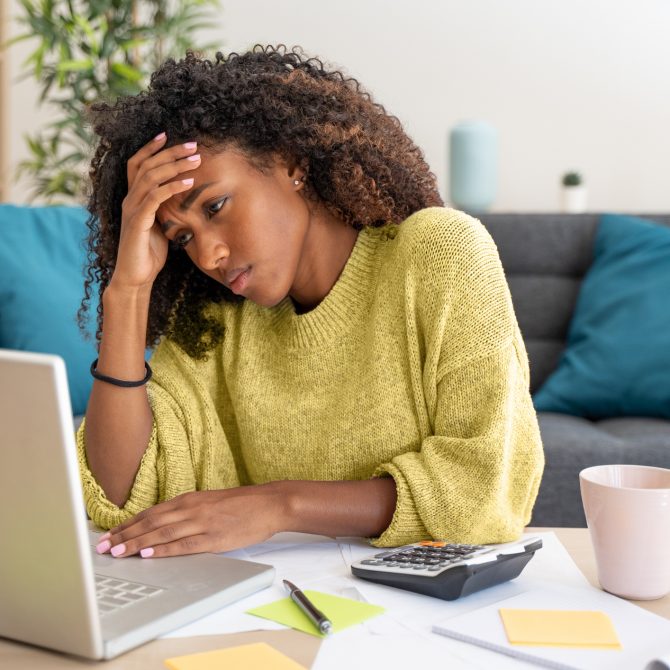 Stressed black woman working at home alone