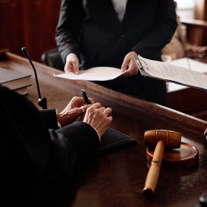 Judge reviewing documents at the bench with gavel in court during a personal injury trial