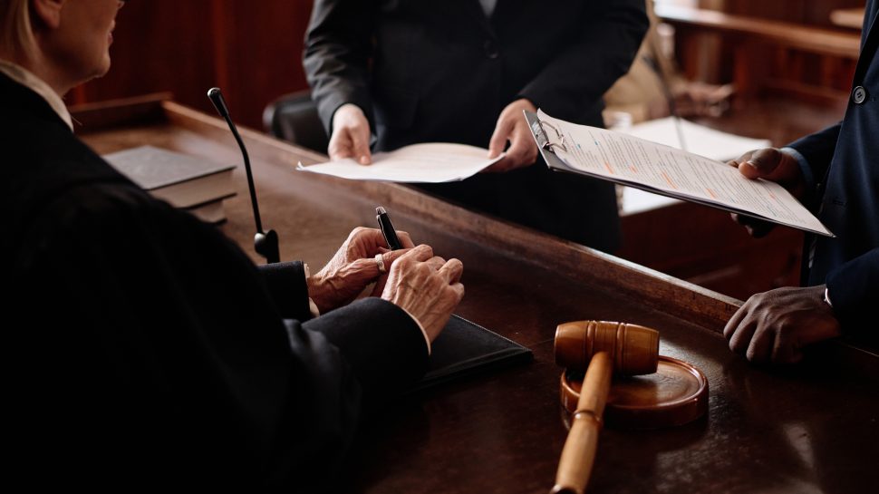 Judge reviewing documents at the bench with gavel in court during a personal injury trial